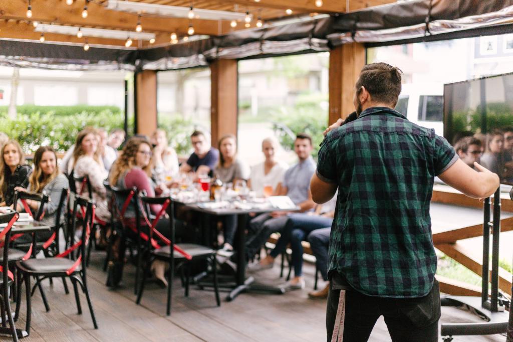 A young man giving a speech in front of an audience.