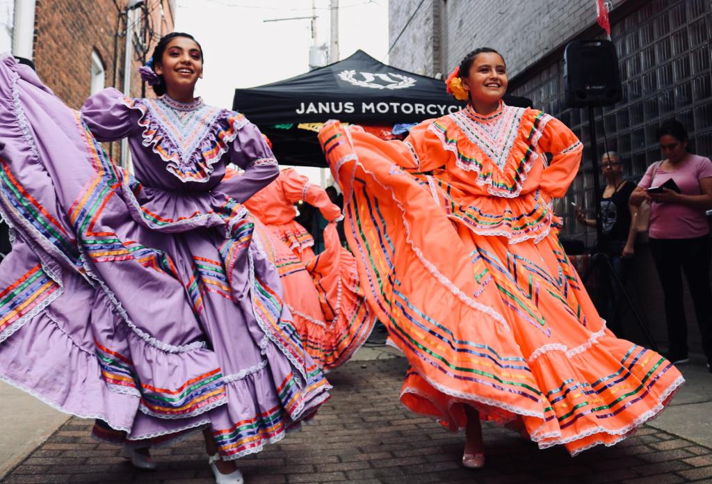 A group of young girls dancing traditional Mexican music.